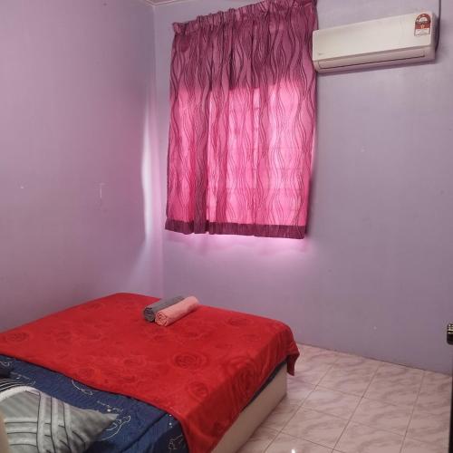 a bedroom with a red bed and a window at Mastermind Malay Semeling Homestay in Bedung