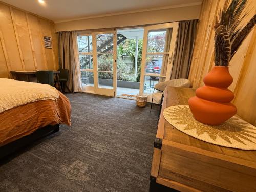 a bedroom with a bed and a vase on a table at Te Anau Lakefront Backpackers in Te Anau