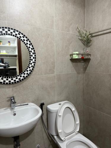Un baño con lavabo, inodoro y espejo. en Pollux Superior 2 seaview by Superstay, en Batam Centre