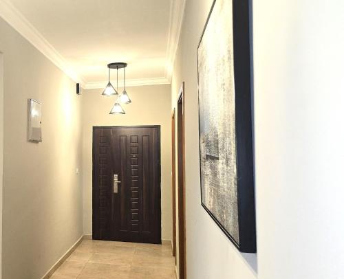 a hallway with a black door and a picture at THE POOL LABONE in Accra