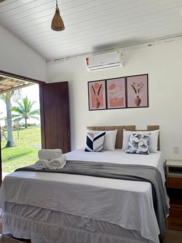 a bedroom with a large bed with pillows at Casa Sol e mar in Porto Seguro