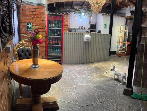 a dog standing next to a table in a room at Tlv HOSTEL in Cusco