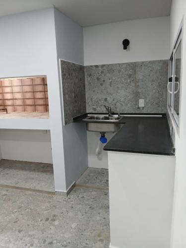 an empty kitchen with a sink and a counter at Serena in Concepción del Uruguay
