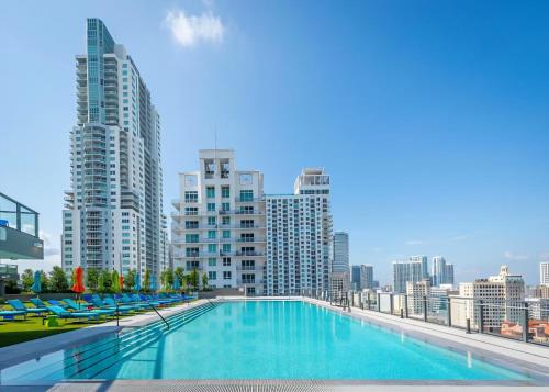 a swimming pool on the roof of a building with tall buildings at Downtown Luxe Studio in Miami