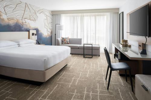a bedroom with a bed and a desk and a couch at Tampa Airport Marriott in Tampa