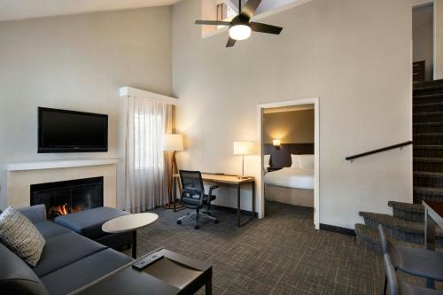 a living room with a couch and a room with a bed at Residence Inn Anaheim Placentia/Fullerton in Placentia