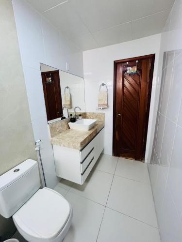 a white bathroom with a toilet and a sink at Jardim das Pérolas 101 in Belém