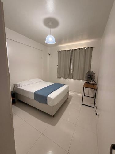 a white bedroom with a bed and a window at Jardim das Pérolas 101 in Belém