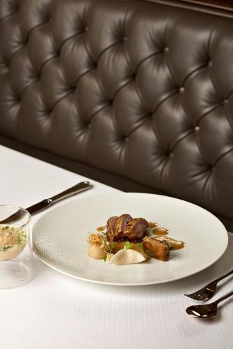 a plate of food on a table with a couch at Hotel Imperial, a Luxury Collection Hotel, Vienna in Vienna