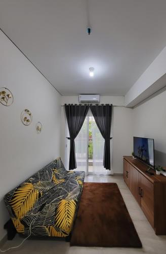 a living room with a bed and a television at Apartemen 2 Kamar Podomoro in Medan