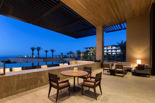 a patio with a table and chairs and the ocean at JW Marriott Los Cabos Beach Resort & Spa in San José del Cabo