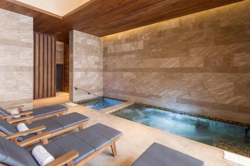 a swimming pool with two lounge chairs and a swimming pool at JW Marriott Los Cabos Beach Resort & Spa in San José del Cabo