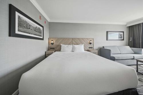a hotel room with a large bed and a chair at Sandman Hotel Red Deer in Red Deer