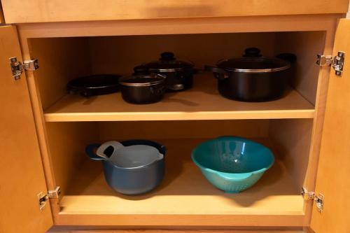 a cabinet with some pots and pans in it at Uptown 1BR Apartment Walkable Fayette 102 in Martinsville