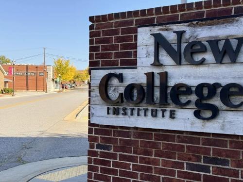 a new college institute sign on the side of a brick building at Uptown 1BR Apartment Walkable Fayette 102 in Martinsville