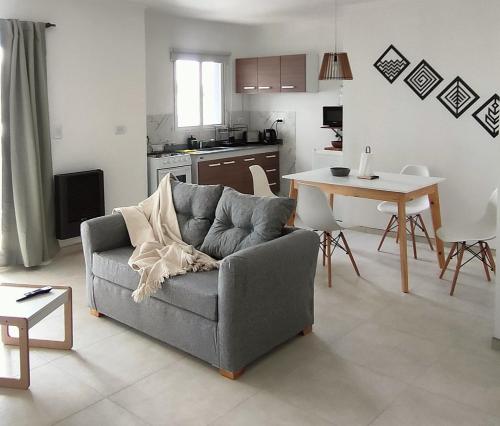 un soggiorno con un divano e un tavolo di Tu departamento en Olavarría te espera! a Olavarría