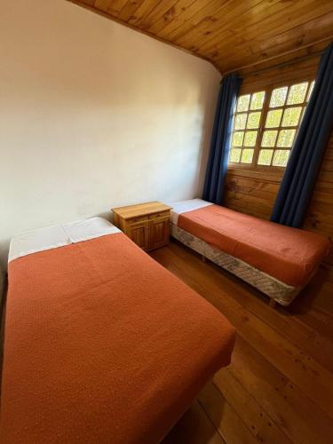 an attic room with two beds and a window at Pucon Antu I - De la Montaña in Esquel