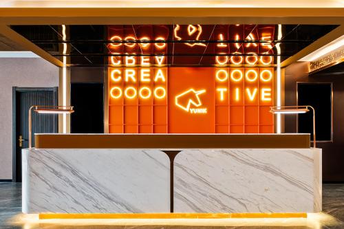 a counter in a room with a sign on a wall at YUNlK Hotel in Harbin