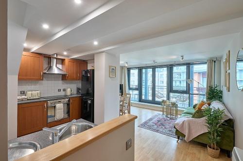a kitchen and living room with a large window at Luxury 2-Bed Penthouse In Deansgate I Free Parking in Manchester