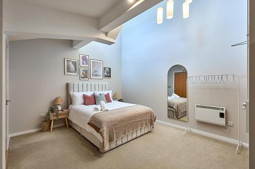 a bedroom with a large bed and a mirror at Luxury 2-Bed Penthouse In Deansgate I Free Parking in Manchester