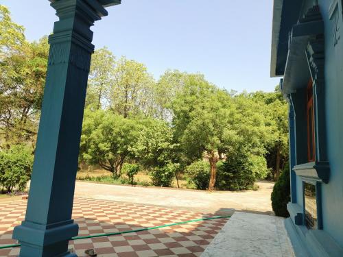 a blue pillar on a building with trees in the background at Adichunchangiri Mahasamsthana Math in Naimishāranya