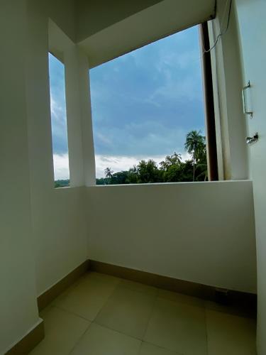 an empty room with a large window with a view at Lakeview Nest in kolkata