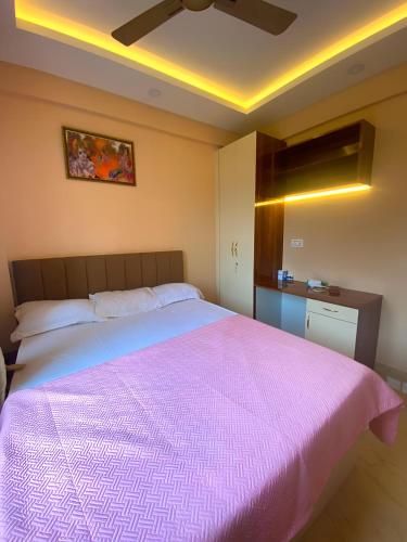 a bedroom with a large bed with a pink blanket at Lakeview Nest in kolkata