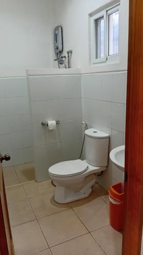 a white bathroom with a toilet and a sink at Freedive Panglao Resort in Panglao Island