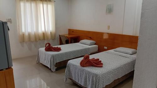a room with two beds with red towels on them at Freedive Panglao Resort in Panglao Island