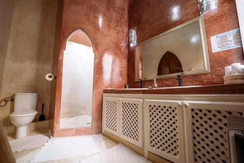 ein Badezimmer mit Toilette, Waschbecken und Spiegel in der Unterkunft Riad Spa Medina Souks in Marrakesch