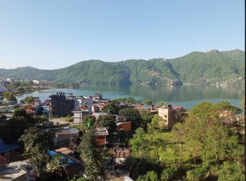 vistas a la ciudad y a un río con montañas en Gate of Himalaya hotel and apartment, en Pokhara