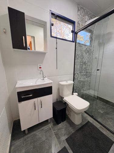 a bathroom with a toilet and a sink and a shower at Santuário Panacéia in Piracaia