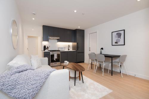 a living room with a white couch and a table at Brand New Cozy Suite near Collingwood School in West Vancouver