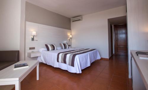 a hotel room with a bed and a table at Hotel Tres Torres in Santa Eularia des Riu