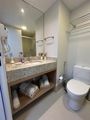 a bathroom with a sink and a toilet and a mirror at Studio moderno e novo - Uni Home 405 - Boa Viagem in Niterói