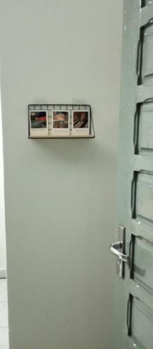 a bathroom door with two pictures on it at Seu Belém - Sua Estadia Paraense in Belém