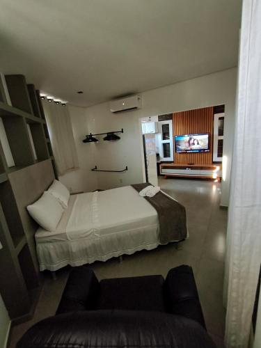 a bedroom with a bed and a couch and a tv at Amoras flat in Sao Jorge