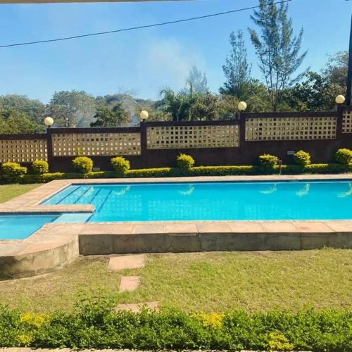 a swimming pool in a yard next to a fence at Casa Bilene in Macia