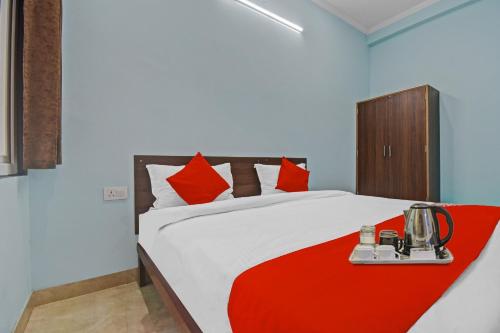 a bedroom with a bed with a red blanket at Hotel O Ansh Plaza in Jaipur