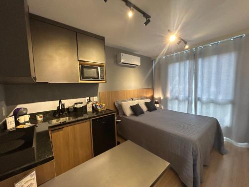 a small room with a bed and a kitchen at Studio moderno e novo - Uni Home 405 - Boa Viagem in Niterói