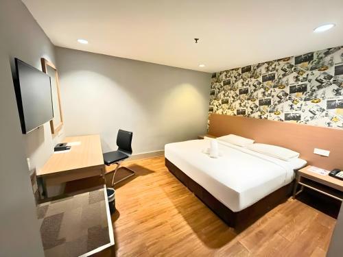 a bedroom with a bed and a desk and a television at Seeds Hotel Premier Pudu Kuala Lumpur Previously Hotel Pudu Plaza KL in Kuala Lumpur