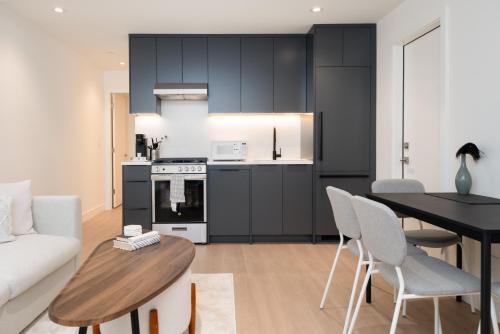 a kitchen and living room with a table and chairs at Brand New Cozy Suite near Collingwood School in West Vancouver