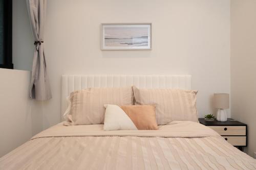 a white bedroom with a white bed with two pillows at Brand New Cozy Suite near Collingwood School in West Vancouver