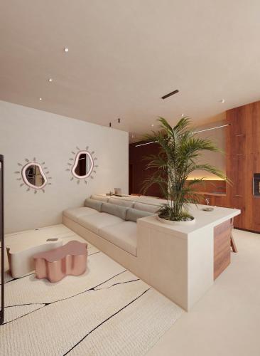 a living room with a couch and a potted plant at Gate 11 Apartments in Denpasar