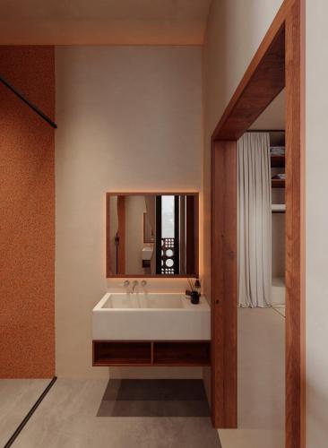 a bathroom with a white sink and a mirror at Gate 11 Apartments in Denpasar