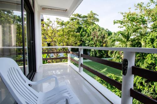 a balcony with white chairs and a view of trees at Babosam Apartments in Boracay