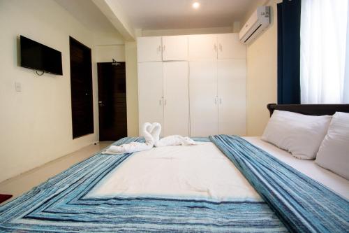 a bedroom with a bed with two towels on it at Babosam Apartments in Boracay
