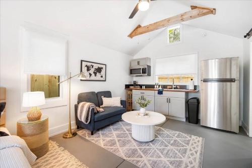 a living room with a couch a table and a kitchen at Luxe King Studio Near AMI! Beach Gear & Fast WiFi in Bradenton