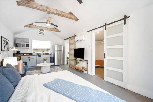 a living room with a blue couch and a kitchen at Luxe King Studio near Anna Maria Island with Private Parking and Beach Gear and WIFI in Bradenton