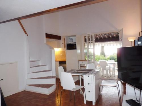 - un salon avec un escalier, une table et des chaises dans l'établissement Charmant mas 4 personnes avec piscine et parking à La Croix-Valmer - FR-1-726-60, à La Croix-Valmer